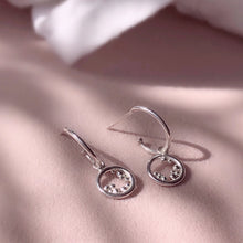 Load image into Gallery viewer, styled shot of silver huggie embrace earrings